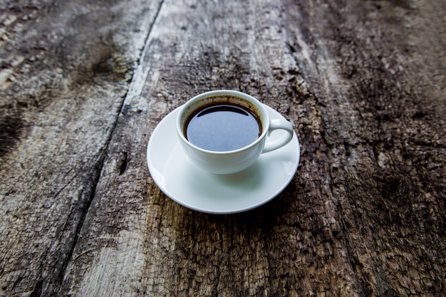 Tazza di caffè calda su una tavola di legno. Caffè in una tazza bianca