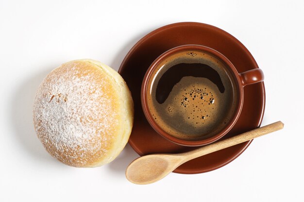 Tazza di caffè caldo con ciambella fresca per colazione su sfondo bianco, vista dall'alto