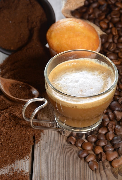 Tazza di caffè caldo con muffin, chicchi di caffè e cannella