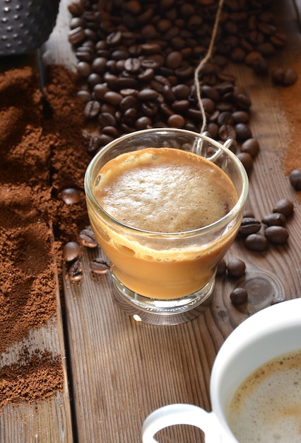 Tazza di caffè caldo con muffin, chicchi di caffè e cannella