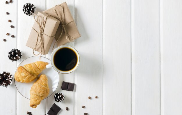 Tazza di caffè caldo con pasticceria, confezioni di Capodanno e pigne