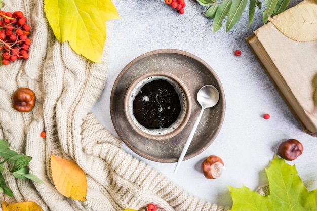 Tazza di caffè caldo coperta e foglie autunnali su sfondo autunnale Concetto di relax autunnale tonificante vintage