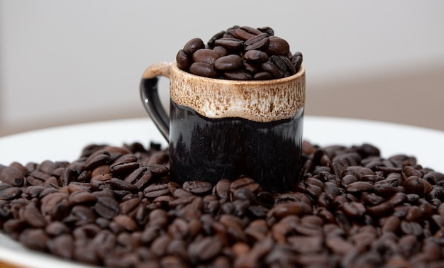 Tazza di caffè caldo direttamente dalla fattoria in chicchi di caffè tostato