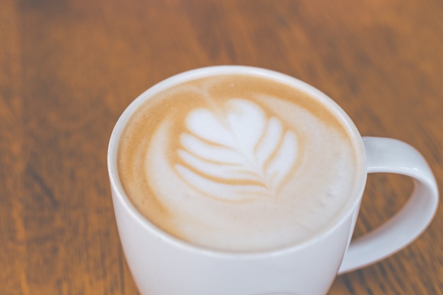 tazza di caffè caldo latte art sul tavolo di legno