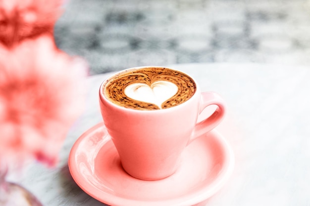 Tazza di caffè caldo latte su sfondo tavolo in marmo con amore art