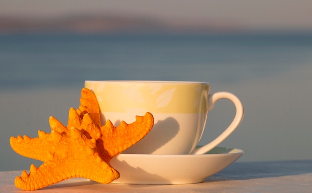 Tazza di caffè caldo mattutino con stelle marine, buongiorno.