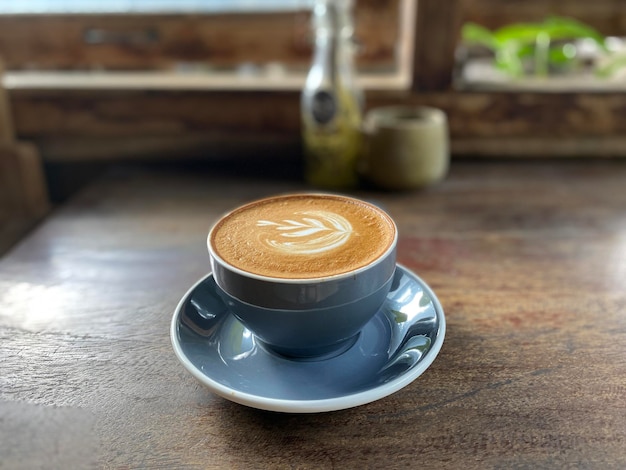 tazza di caffè caldo su tavola di legno, latte art