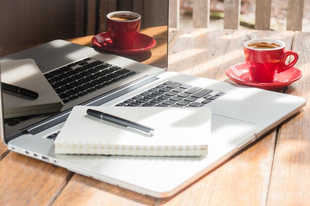 Tazza di caffè caldo sul posto di lavoro in legno