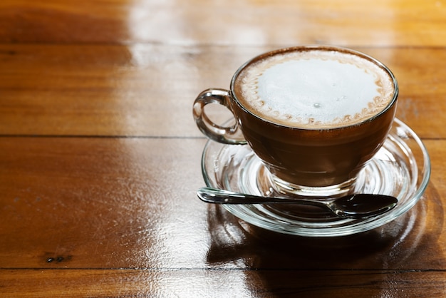 Tazza di caffè caldo sul tavolo di legno, sottoesposizione