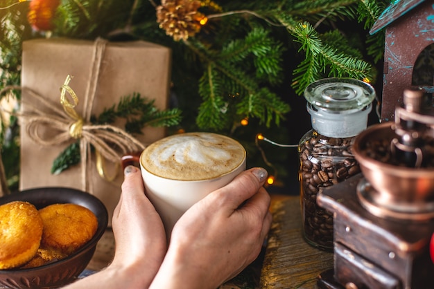 Tazza di caffè cappuccino con rami verdi di un albero di Natale