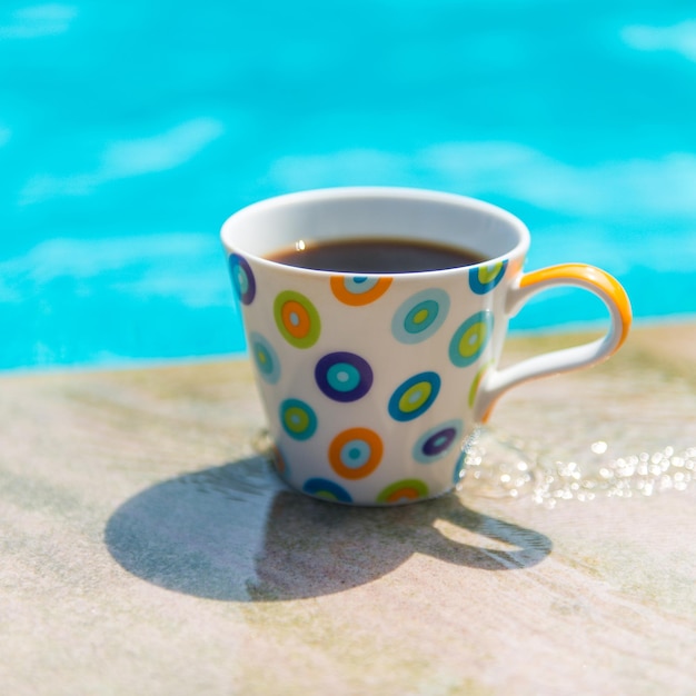 Tazza di caffè colorata sulla piscina