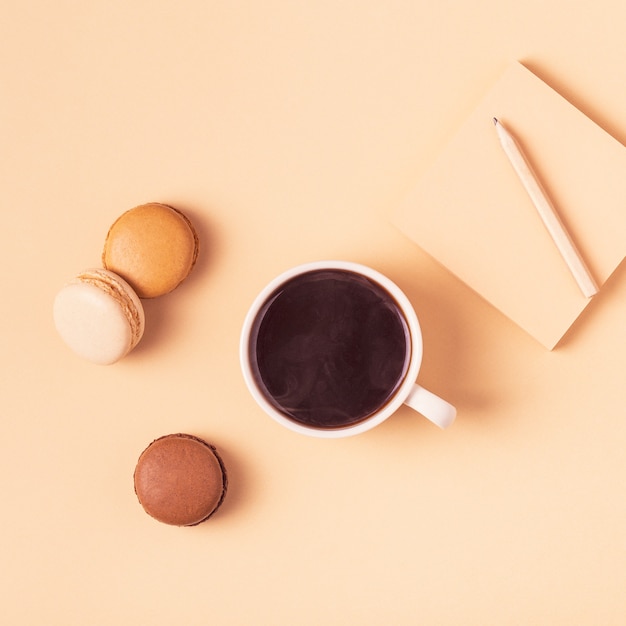 Tazza di caffè con amaretti su sfondo pastello