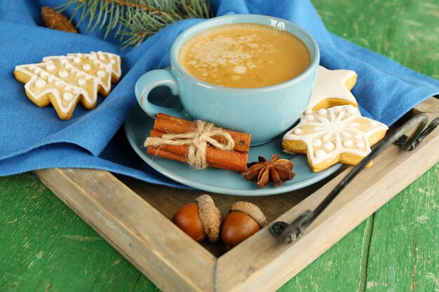 Tazza di caffè con biscotti a forma di stella sul tovagliolo sul vassoio di legno