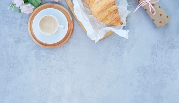 Tazza di caffè con bouquet di tulipani rosa e croissant su sfondo bianco shabby chic. San Valentino, madri, festa della donna concetto di mattina. Colazione di San Valentino