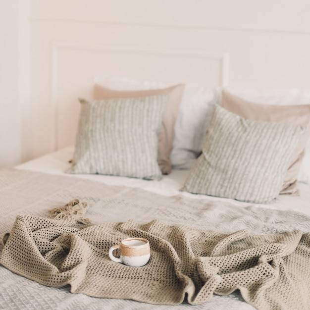 Tazza di caffè con caldo plaid a letto