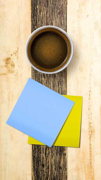 Tazza di caffè con carta vuota su sfondo di legno Concetto di giornata internazionale del caffè