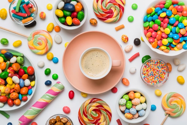 Tazza di caffè con cioccolatini e caramelle colorate Vista superiore sullo sfondo del tavolo con spazio di copia