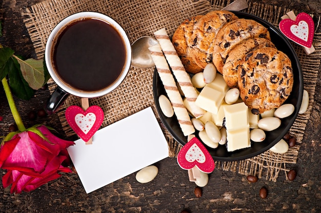 Tazza di caffè con cioccolato bianco, mandorle e biscotti