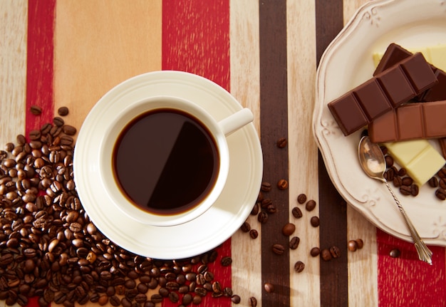 Tazza di caffè con cioccolato e chicchi di caffè