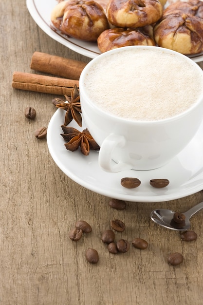 Tazza di caffè con fagioli e torte su fondo di legno