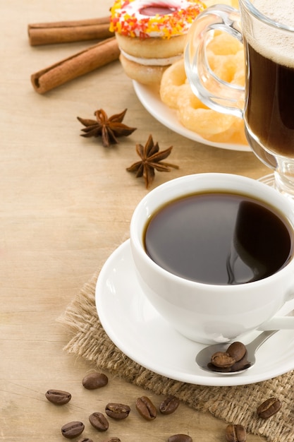 Tazza di caffè con fagioli e torte su fondo di legno