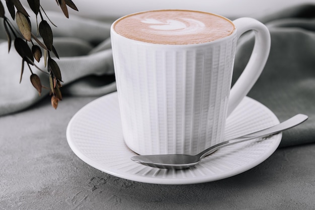 Tazza di caffè con fiore cuore dipinto su schiuma