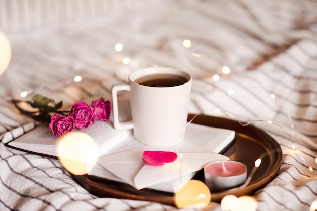 Tazza di caffè con fiori sul libro aperto. Buon giorno. San Valentino.