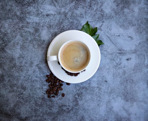 tazza di caffè con grani su sfondo grigio