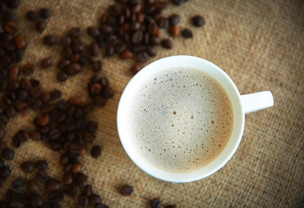 Tazza di caffè con i fagioli sulla vista superiore del sacco