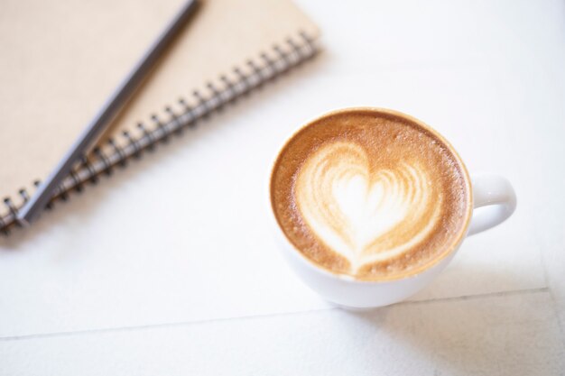 Tazza di caffè con il taccuino sul tavolo