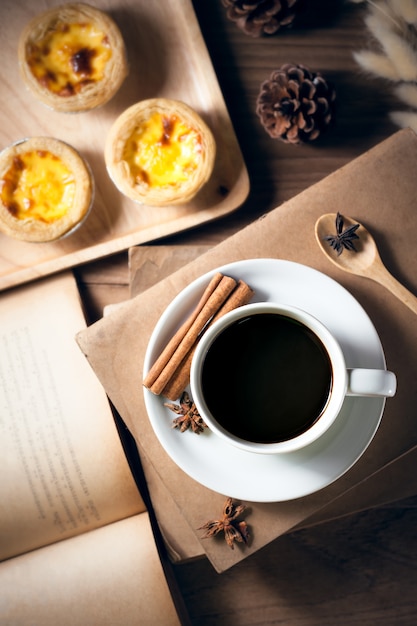 Tazza di caffè con il vecchio libro sulla tavola di legno rustica, concetto classico.