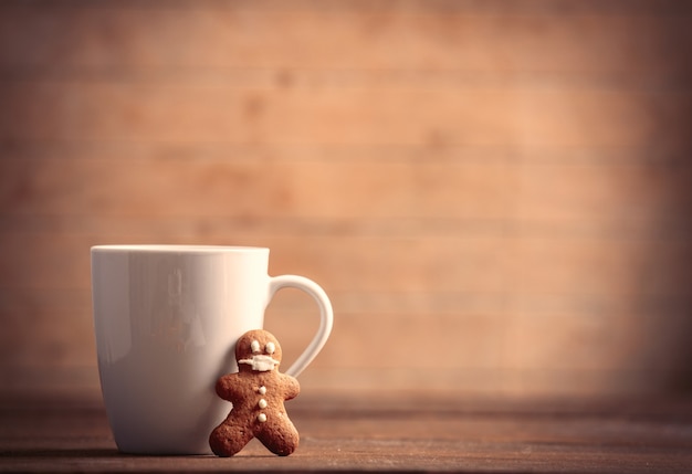 Tazza di caffè con omino di pan di zenzero sulla tavola di legno