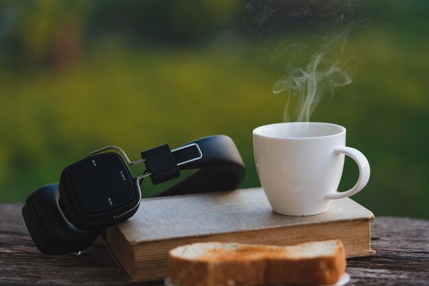 Tazza di caffè con pane su sfondo sfocato verde