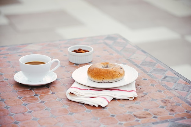 Tazza di caffè con pane sul tavolo al mattino con la luce del sole, colazione