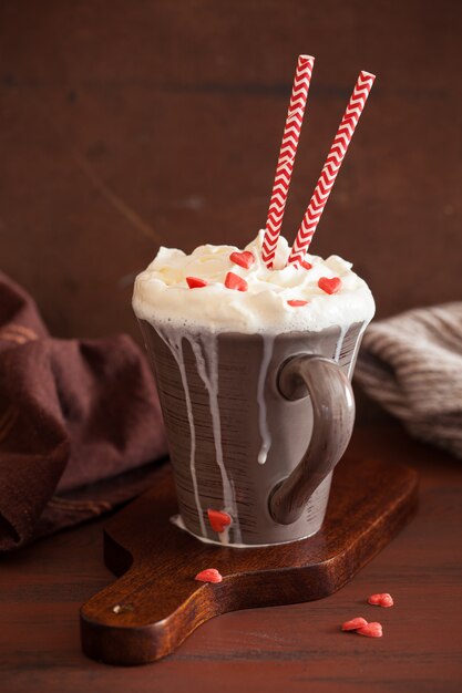 Tazza di caffè con panna montata e cuori rossi