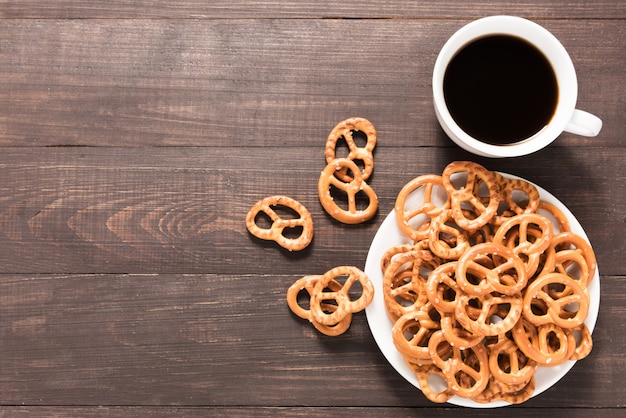 Tazza di caffè con salatini su fondo di legno