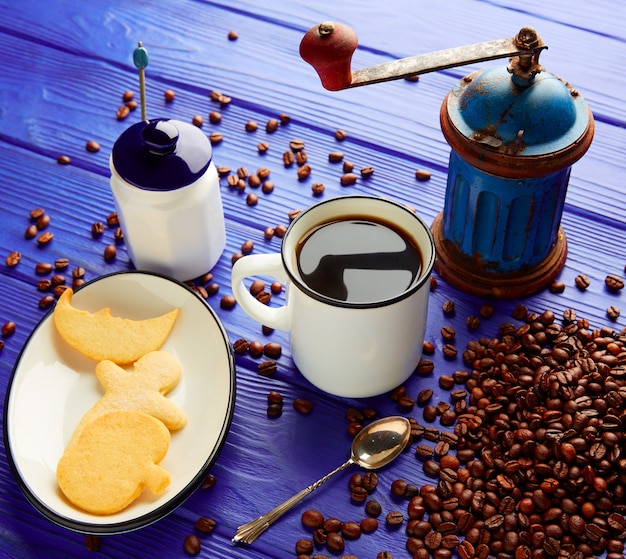 Tazza di caffè con smerigliatrice vintage sul tavolo di legno