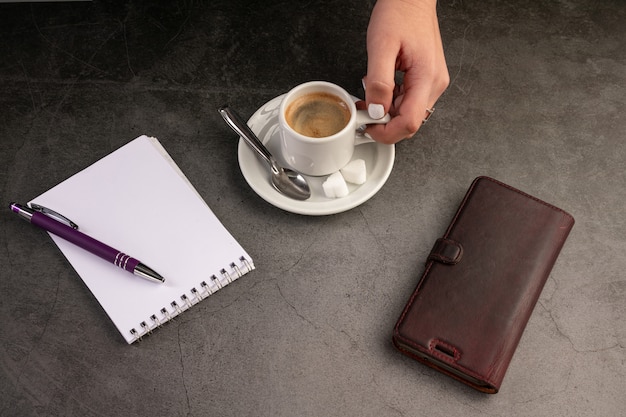 Tazza di caffè con un telefono e un quaderno