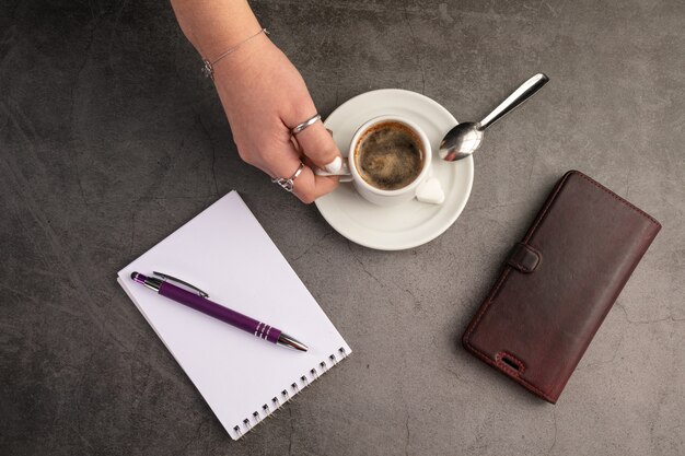 Tazza di caffè con un telefono e un quaderno