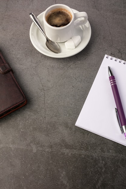 Tazza di caffè con un telefono e un quaderno