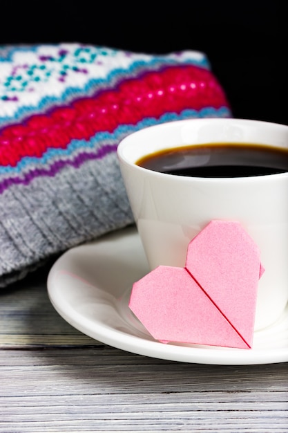 Tazza di caffè con una nota romantica a forma di cuore rosa