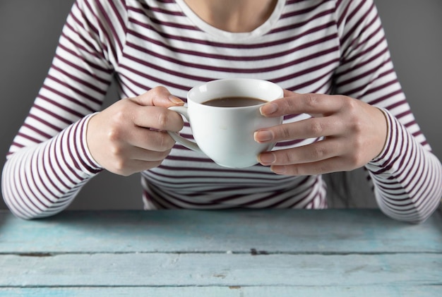 Tazza di caffè della mano della donna