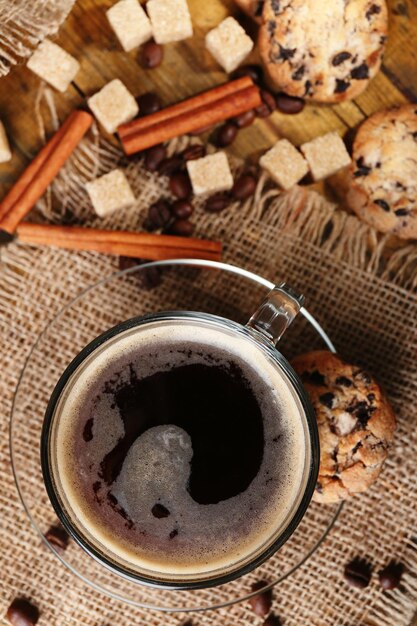 Tazza di caffè di vetro e biscotto saporito su fondo di legno