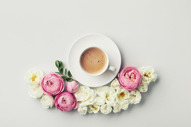 Tazza di caffè e bella composizione con fiori di rosa e bianchi Vista dall'alto e stile piatto