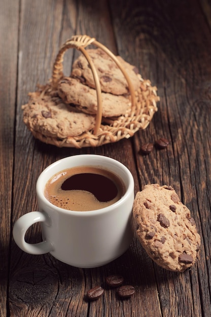 Tazza di caffè e biscotti al cioccolato su un tavolo in legno rustico