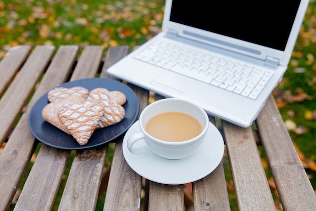 Tazza di caffè e biscotti con il computer portatile