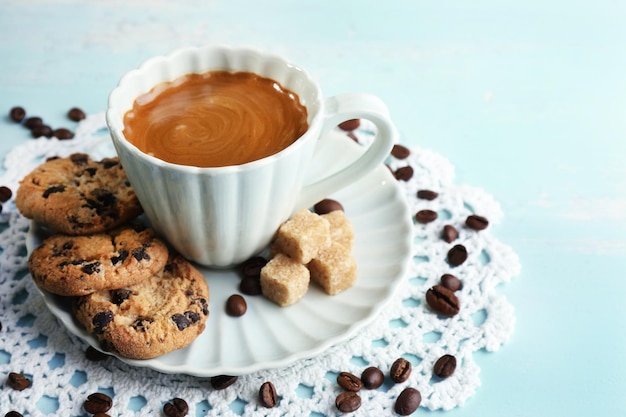 Tazza di caffè e biscotto saporito su fondo di legno di colore