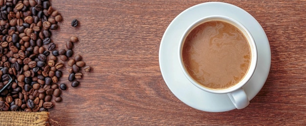 Tazza di caffè e chicchi di caffè in un sacco su sfondo marrone vista dall'alto