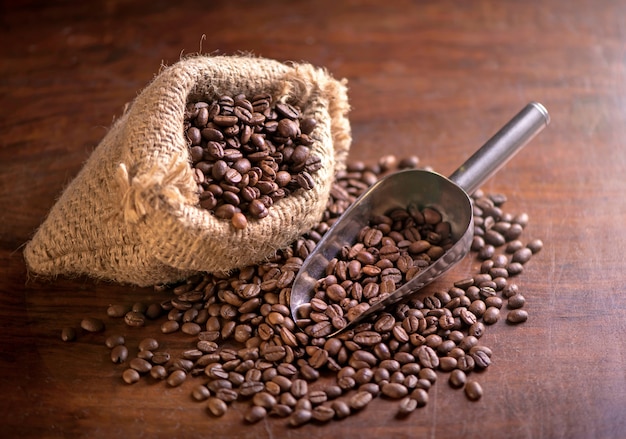 Tazza di caffè e chicchi di caffè in un sacco su sfondo scuro, vista dall'alto