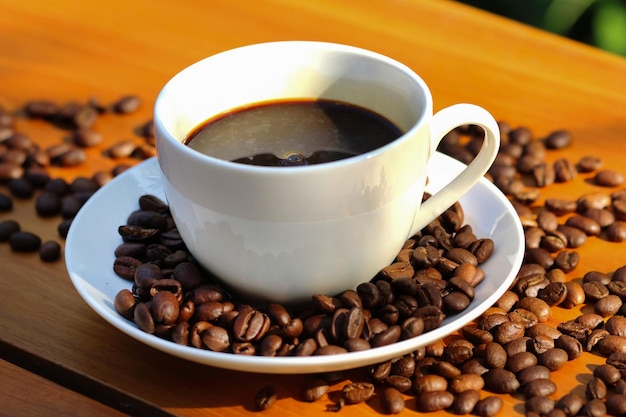 Tazza di caffè e chicchi di caffè su fondo di legno blu